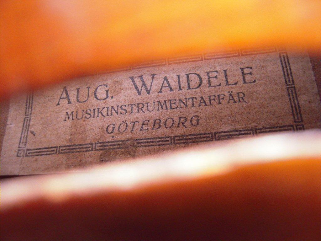 Waideles musikaffär i Göteborg. Waideles kom från Markneukirchen Tyskland och kom till Göteborg 1911. Denna fiol är säkert byggd i hans födelsestad. Fin fiol med bra ton. Firman lades ned 1966.